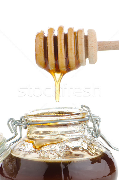 Stock photo: Jar of honey with wooden drizzler