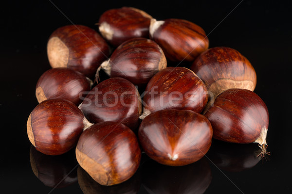 Stock photo: Chestnuts on a black reflective background