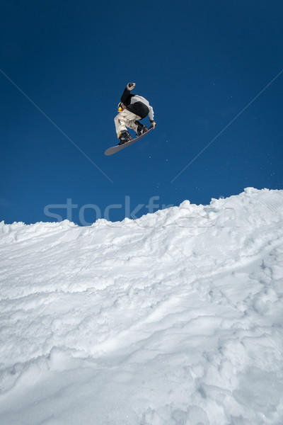 Snowboarder jumping against blue sky Stock photo © homydesign