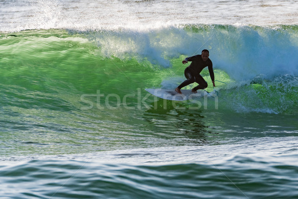 Long boarder surfing the waves at sunset Stock photo © homydesign