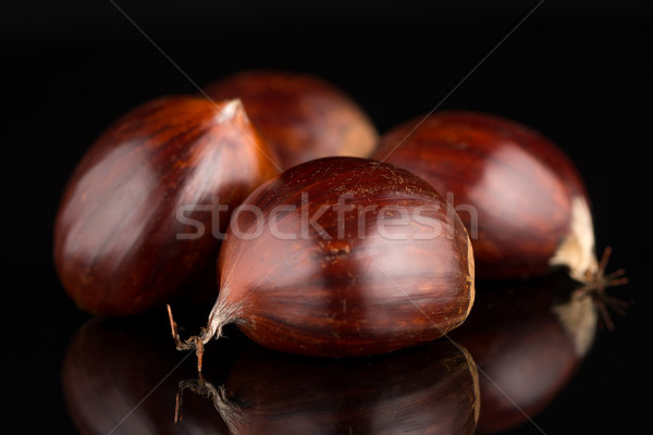Stock photo: Chestnuts on a black reflective background