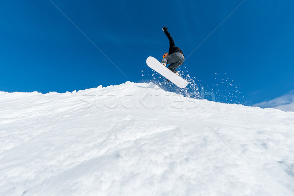 Snowboarder jumping against blue sky Stock photo © homydesign