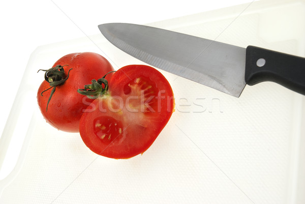 Cutting white plastic board with a knife and tomato Stock photo © homydesign