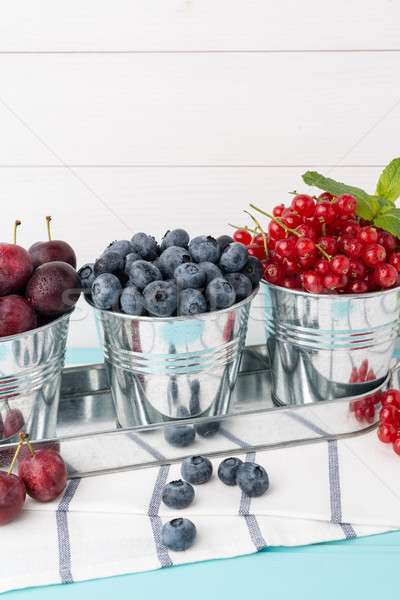Plums, red currants and blueberries in small metal bucket Stock photo © homydesign