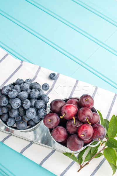 Plums and blueberries in small metal bucket Stock photo © homydesign