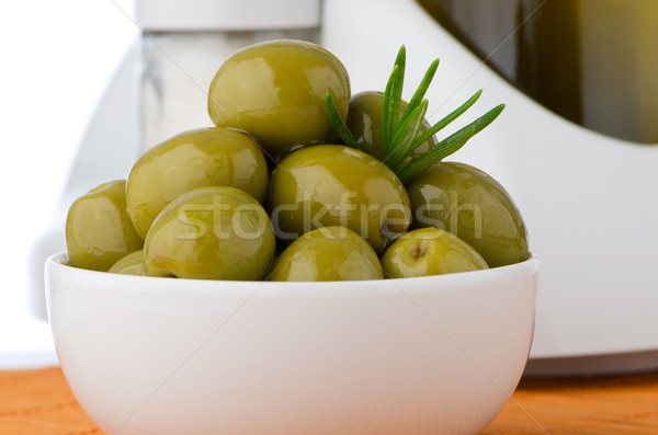 Green olives in a white ceramic bowl Stock photo © homydesign