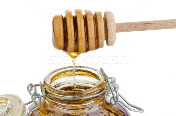 Stock photo: Jar of honey with wooden drizzler