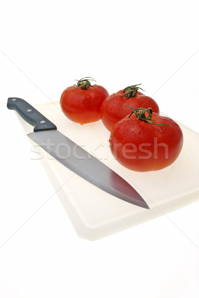 Cutting white plastic board with a knife and tomato Stock photo © homydesign