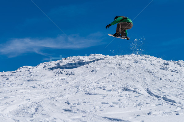 Snowboarder jumping against blue sky Stock photo © homydesign