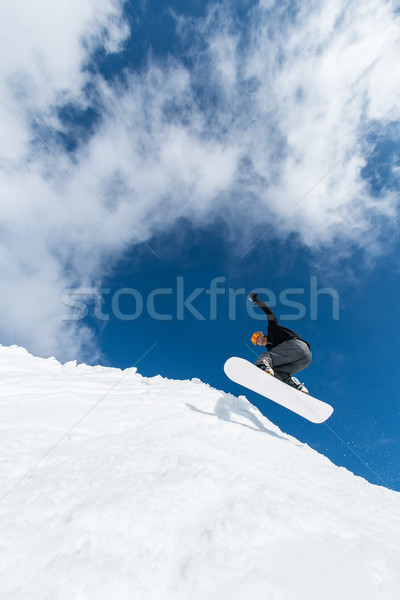 Snowboarder jumping against blue sky Stock photo © homydesign