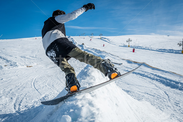 Snowboarder sliding against blue sky Stock photo © homydesign
