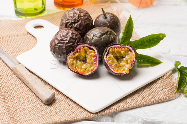 Passion fruits on white ceramic tray on wooden table background. Stock photo © homydesign