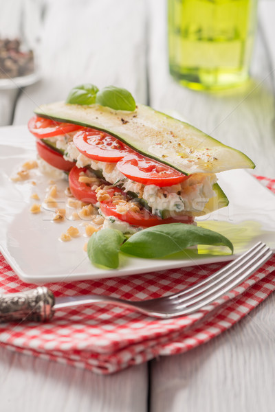 of tomato, zucchini slices, nuts, basil and fresh cheese
