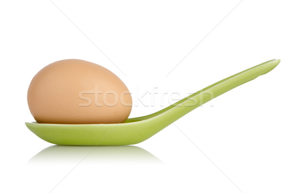 Brown egg in a green ceramic spoon Stock photo © homydesign