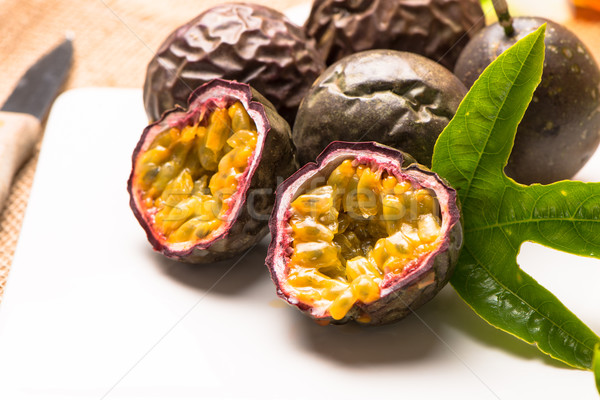 Passion fruits on white ceramic tray on wooden table background. Stock photo © homydesign