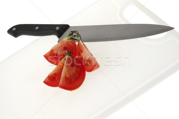 Cutting white plastic board with a knife and tomato Stock photo © homydesign