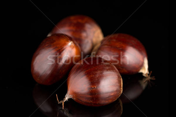 Chestnuts on a black reflective background Stock photo © homydesign