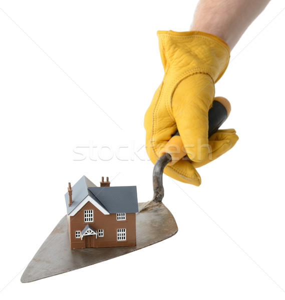 presenting a house on a trowel isolated on a white background Stock photo © hyrons