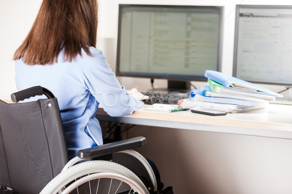 Invalid or disabled woman sitting wheelchair working office desk computer Stock photo © ia_64
