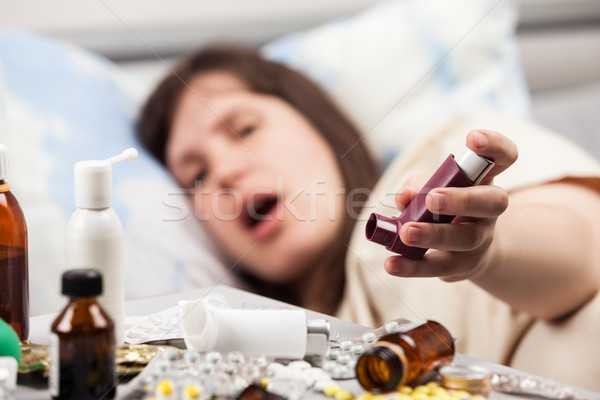 Woman patient in bed hand holding asthmatic inhaler Stock photo © ia_64