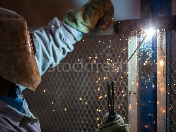 Arc welder worker in protective mask welding metal construction Stock photo © ia_64