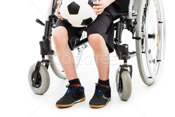 Disabled child boy sitting on wheelchair holding soccer ball Stock photo © ia_64