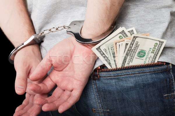 Stock photo: Handcuffs on hands hiding money