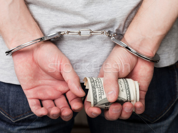 Stock photo: Handcuffs on hands holding money