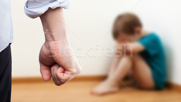 Angry man raised fist over wall corner sitting child boy Stock photo © ia_64