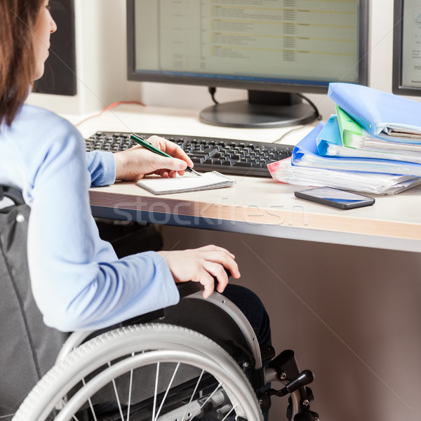 Invalid or disabled woman sitting wheelchair working office desk computer Stock photo © ia_64