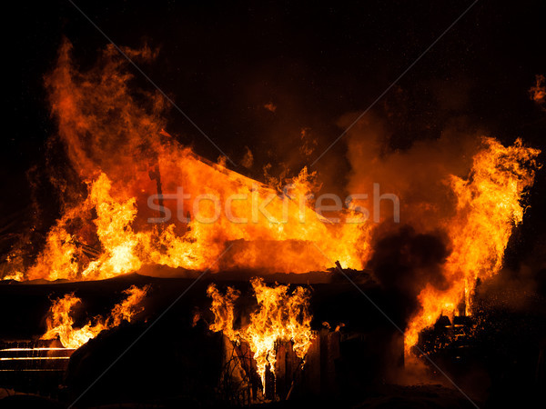 Stock photo: Burning fire flame on wooden house roof