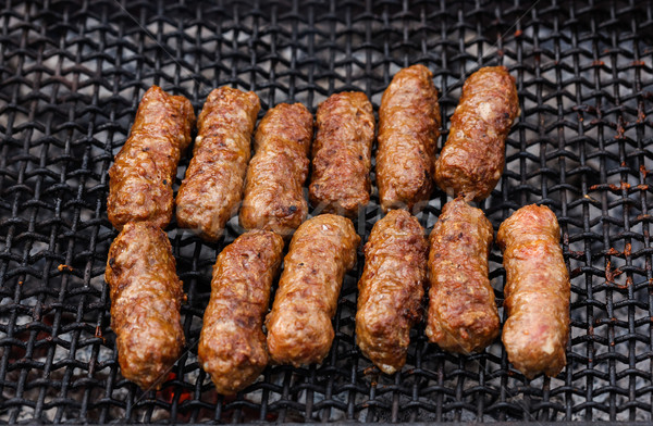 Grilled Romanian meat rolls on barbecue grid - mititei, mici Stock photo © icefront