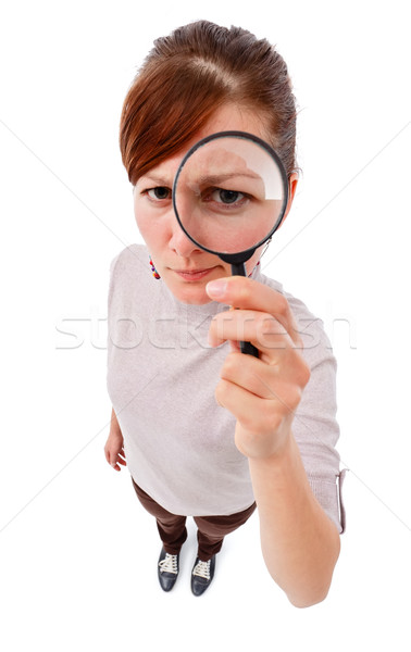 Stock photo: Serious woman as detective with magnifier