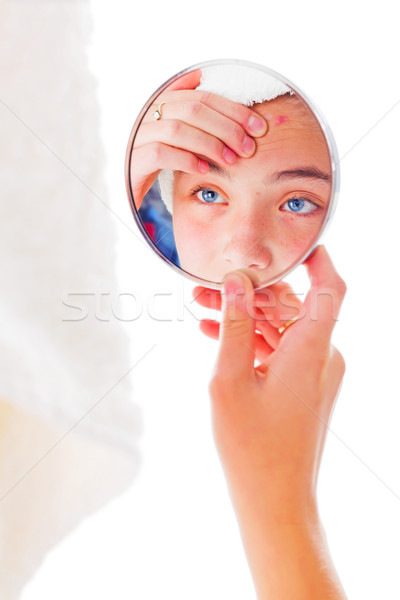Girl looking at her pimples in the mirror Stock photo © icefront