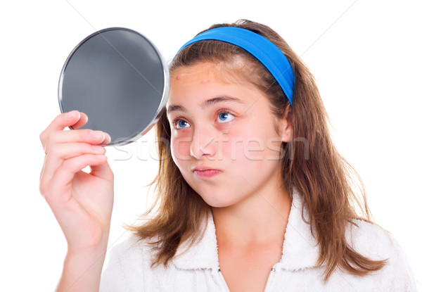Girl examine her pimples in the mirror Stock photo © icefront