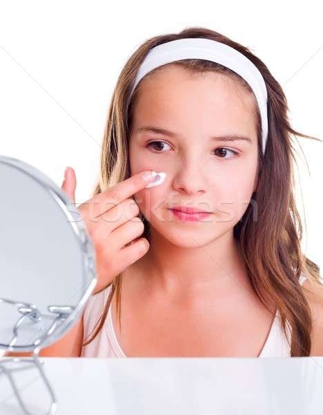 Teenage girl creaming her face Stock photo © icefront