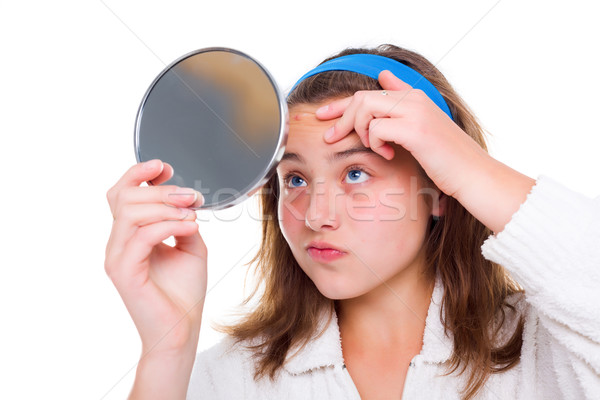Girl examine her pimples in the mirror Stock photo © icefront