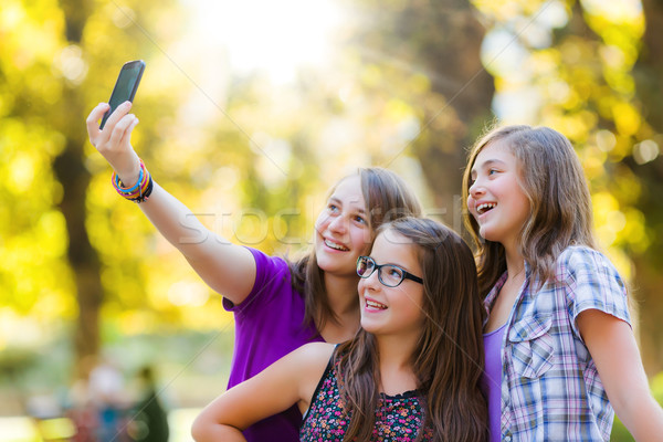 Szczęśliwy teen dziewcząt parku telefonu komórkowego Zdjęcia stock © icefront