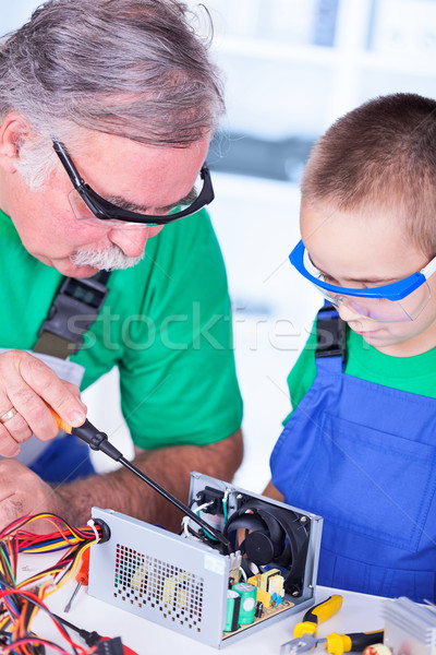 Grandfather explaining the inside of a PC power supply Stock photo © icefront