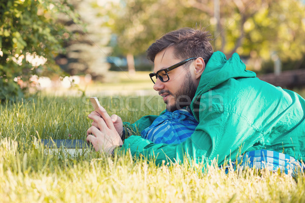 Stock photo: Chilling hipster in park with smartphone