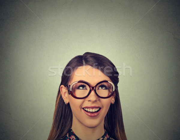 Happy woman looking up wondering isolated on gray wall background
 Stock photo © ichiosea