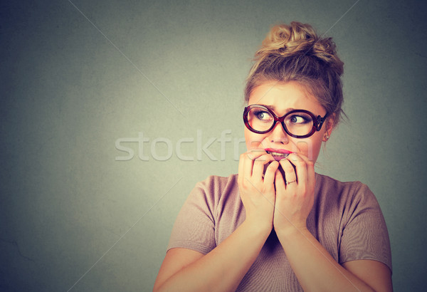 nervous stressed young nerdy woman in glasses biting fingernails looking anxiously Stock photo © ichiosea