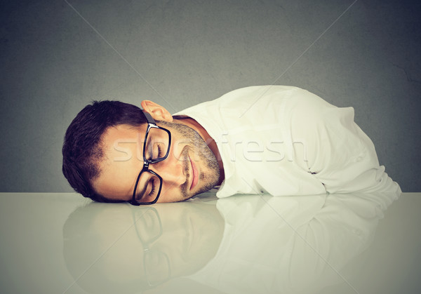 Stock photo: Man with glasses sleeping on a desk