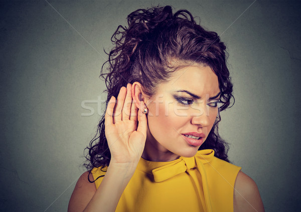 Curious worried woman with hand to ear carefully listening to gossip conversation  Stock photo © ichiosea