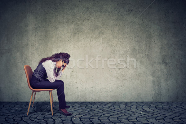 Stock photo: Woman feeling stress from work sitting on chair and looking down 