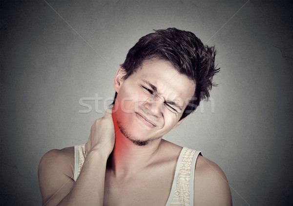 Stressed young handsome man with neck pain colored in red  Stock photo © ichiosea