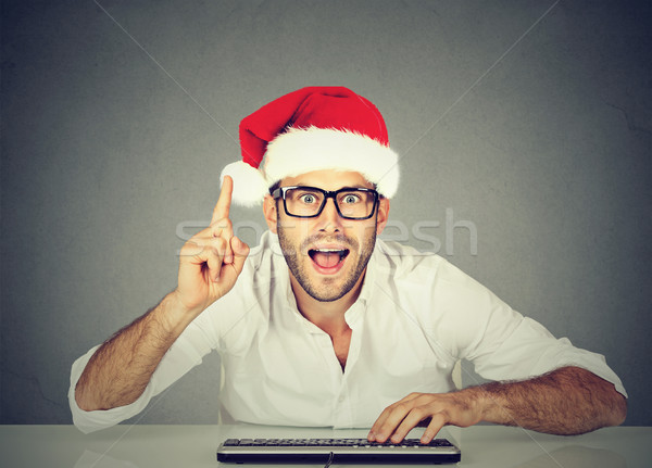 Happy christmas man in red santa claus hat buying stuff online. Holiday xmas shopping  Stock photo © ichiosea