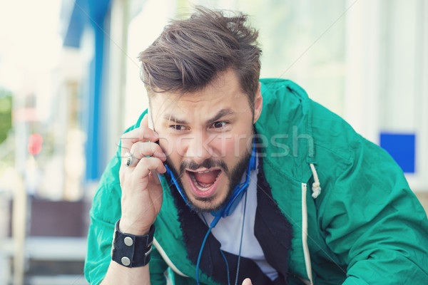 angry young man screaming on mobile phone outdoors  Stock photo © ichiosea