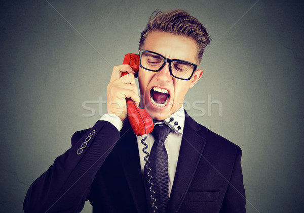 Stock photo: Angry young business man yelling on the phone