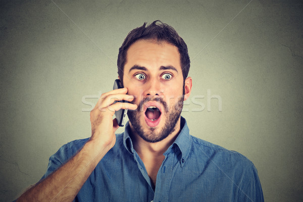 Shocked man talking on mobile phone  Stock photo © ichiosea